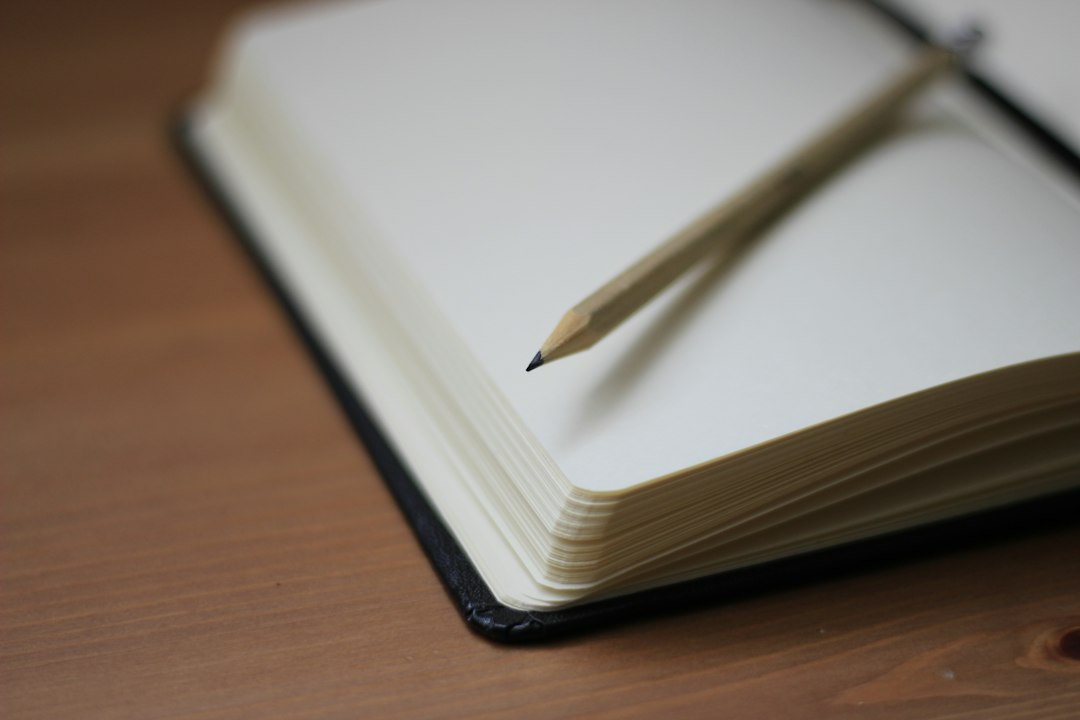A pencil resting on an open notebook.