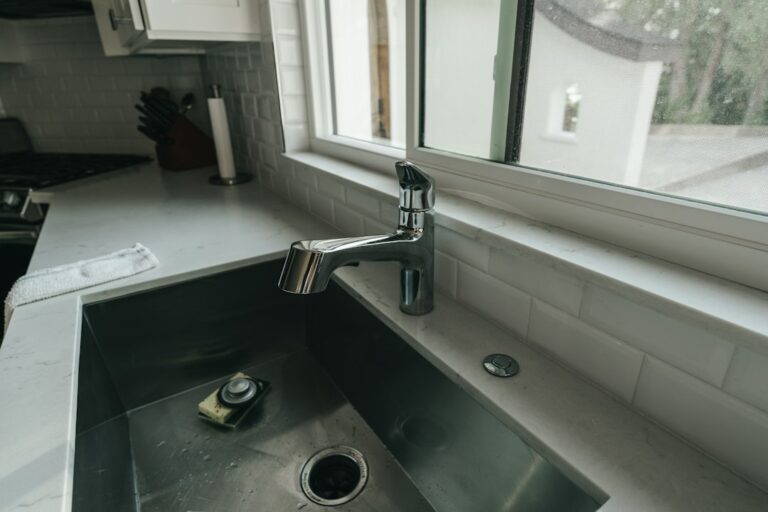 A kitchen sink beneath a window.